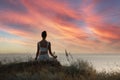 Woman meditating on hill near sea, back view. Space for text Royalty Free Stock Photo