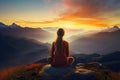 Woman meditating in lotus pose on top of mountain during sunrise, Female meditating on top of a mountain with beautiful sunset Royalty Free Stock Photo