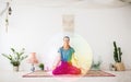 Woman meditating in lotus pose at yoga studio