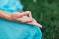 Woman meditating in lotus position closeup. Hands close-up mudra. Sitting on rug the lawn of green grass background Royalty Free Stock Photo