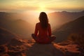 Woman meditating in lotus position on mountain peak during sunrise, Female meditating on top of a mountain with beautiful sunset Royalty Free Stock Photo