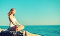 Woman meditating in lotus yoga on beach