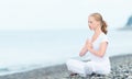 Woman meditating in lotus yoga on beach Royalty Free Stock Photo