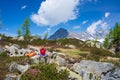 Woman meditating in natural environment on the mountains. One person sitting on rock in lotus pose in beautiful alpine ambient