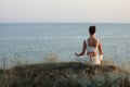 Woman meditating near sea, back view. Space for text Royalty Free Stock Photo