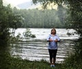 Woman meditating on the river bank