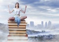 Woman meditating sitting meditating on Books stacked by distant city Royalty Free Stock Photo