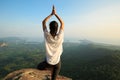 Woman meditating on sunrise mountain peak Royalty Free Stock Photo