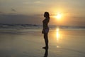 Woman meditating and thinking peacefully on desert beach on sunset in meditation and freedom Royalty Free Stock Photo