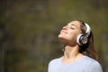 Woman meditating wearing headphones in a park Royalty Free Stock Photo