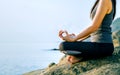 The woman meditating in a yoga pose on the tropical beach. Female meditating overlooking the beautiful sunrise. Healthy mind body Royalty Free Stock Photo