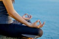 The woman meditating in a yoga pose on the tropical beach. Female meditating overlooking the beautiful sunrise. Healthy mind body Royalty Free Stock Photo