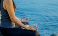 The woman meditating in a yoga pose on the tropical beach. Female meditating overlooking the beautiful sunrise. Healthy mind body Royalty Free Stock Photo