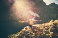 Woman meditating yoga sitting on cliff alone sun light Royalty Free Stock Photo