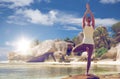 Woman meditating in yoga tree pose over beach Royalty Free Stock Photo