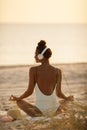 Woman in Yoga Meditation Pose with Headphones on the Beach Royalty Free Stock Photo
