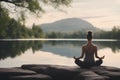 A woman in a meditative yoga pose by a tranquil lake