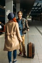 Woman meeting her boyfriend from his trip at the train station. Tourist Man with luggage and photo camers. Travel concept. Redhair