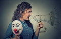 Woman with megaphone and clown mask Royalty Free Stock Photo