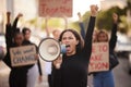 Woman, megaphone and fist in community protest for change, gender based violence or equality in the city. Angry women