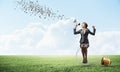 Woman with megaphone sitting on big light bulb Royalty Free Stock Photo