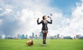 Woman with megaphone sitting on big light bulb Royalty Free Stock Photo