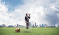 Woman with megaphone sitting on big light bulb Royalty Free Stock Photo