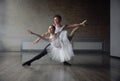 Woman and man ballet dancers in dynamic action against studio background