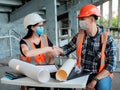 Builders in helmets, vests and medical masks shake hands after signing the contract for the construction of the building