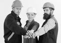 Woman and men in hard hats holds hands together. Team of architects, builders ready to work, isolated white background. Royalty Free Stock Photo