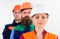 Woman and men in hard hats stand close as team. Royalty Free Stock Photo