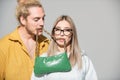 Woman and man holds fashion handbag in mouth. Close up outdoor fashion portrait of stylish young pretty couple in love Royalty Free Stock Photo