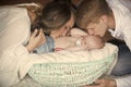 Woman, man kiss newborn child sleep in crib on floor Royalty Free Stock Photo