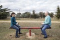 Woman and man mounted on a seesaw maintaining equality