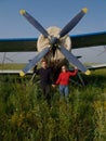 Woman and men portrait in front of an aircraft. Young couple with red jacket stand in front of older bomber aircraft Royalty Free Stock Photo