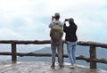 Woman and man tourist using smartphone taking nature photo of mountain landscape Thailand