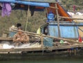 Woman mending nets in  fishing boat in Ha Long Bay Vietnam Royalty Free Stock Photo