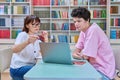 Woman mentor teaching male student in college library, exam preparation Royalty Free Stock Photo