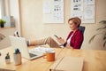 Woman Messaging At Office. Cheerful Woman Holding Mobile And Laughing Royalty Free Stock Photo