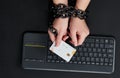 Woman with metal chain holding credit card over keyboard, online shopping addiction concept