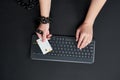 Woman with metal chain holding credit card over keyboard, online shopping addiction concept