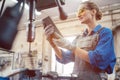 Woman in metal workshop checking workpiece