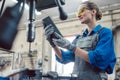 Woman in metal workshop checking workpiece