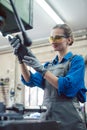 Woman in metal workshop checking workpiece