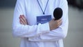 Woman with microphone and press accreditation badge, media pass for journalist