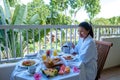 woman mid age having breakfast on their balcony of an appartment luxury hotel condo in Mauritius Royalty Free Stock Photo