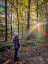 woman mid age walking in the forest during Autumn season in nature trekking with orange red color trees during fall Royalty Free Stock Photo