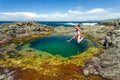 Female leaping into seaside rock pool Royalty Free Stock Photo