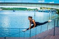 woman middle-aged fitness instructor doing training outdoor summer day city promenade river