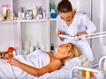 Woman middle-aged lying in spa salon. Tweezing eyebrow beautician.